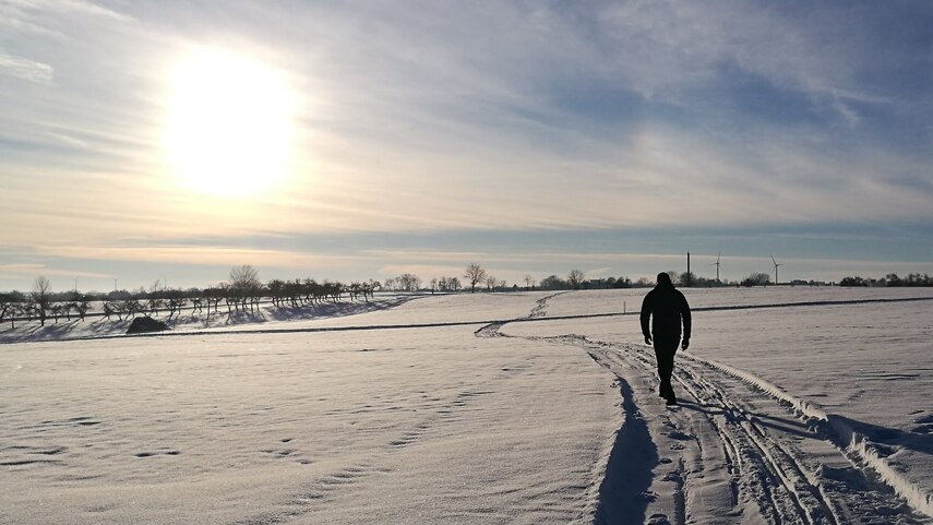 Mann spaziert in Winterlandschaft